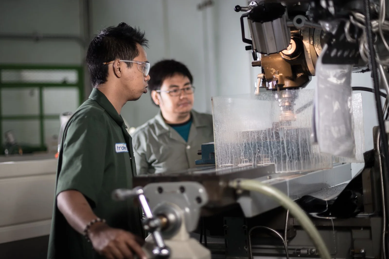 Two technicians reviewing a machining operation together.
