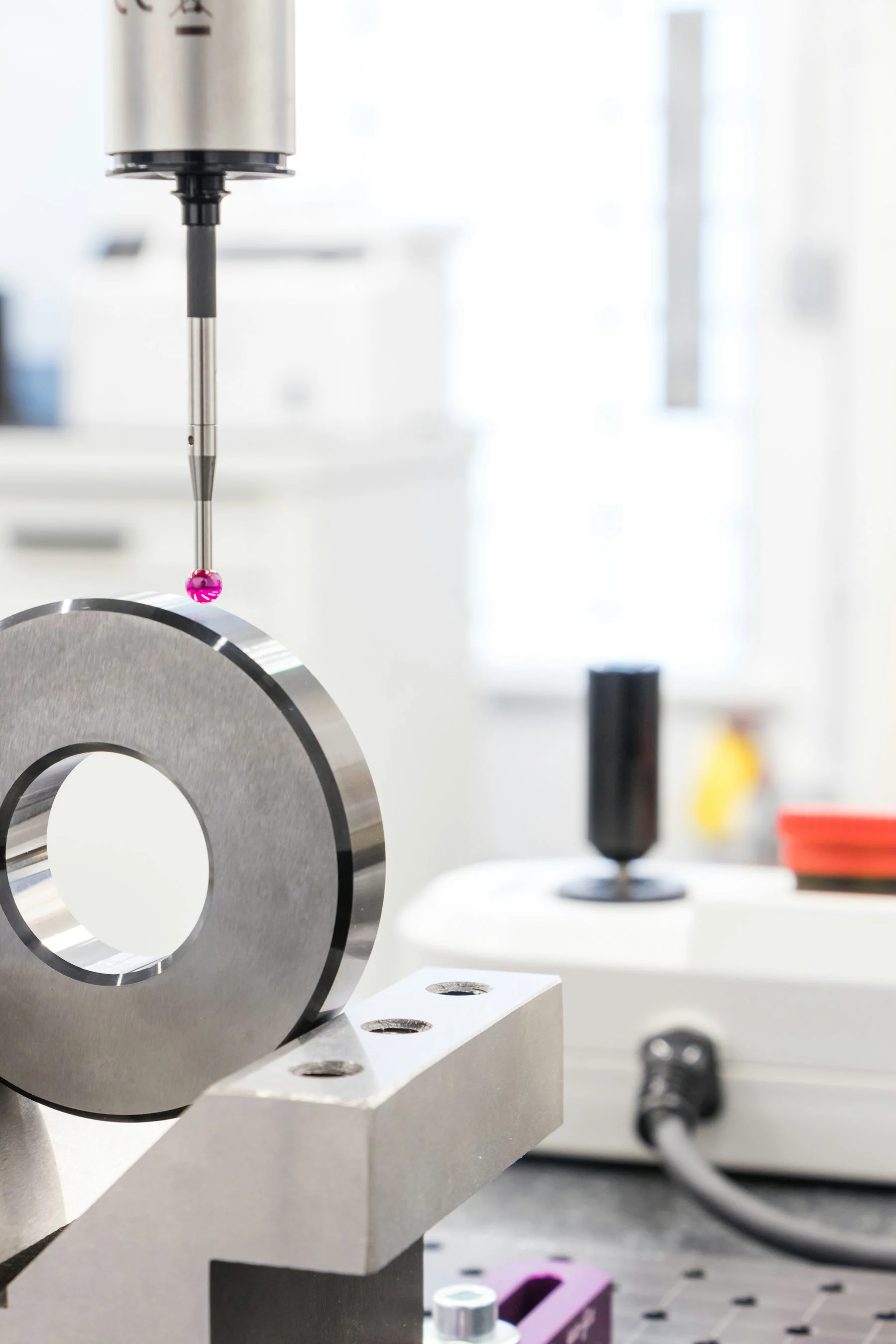 A ruby-tipped measurement probe checking a machined ring.
