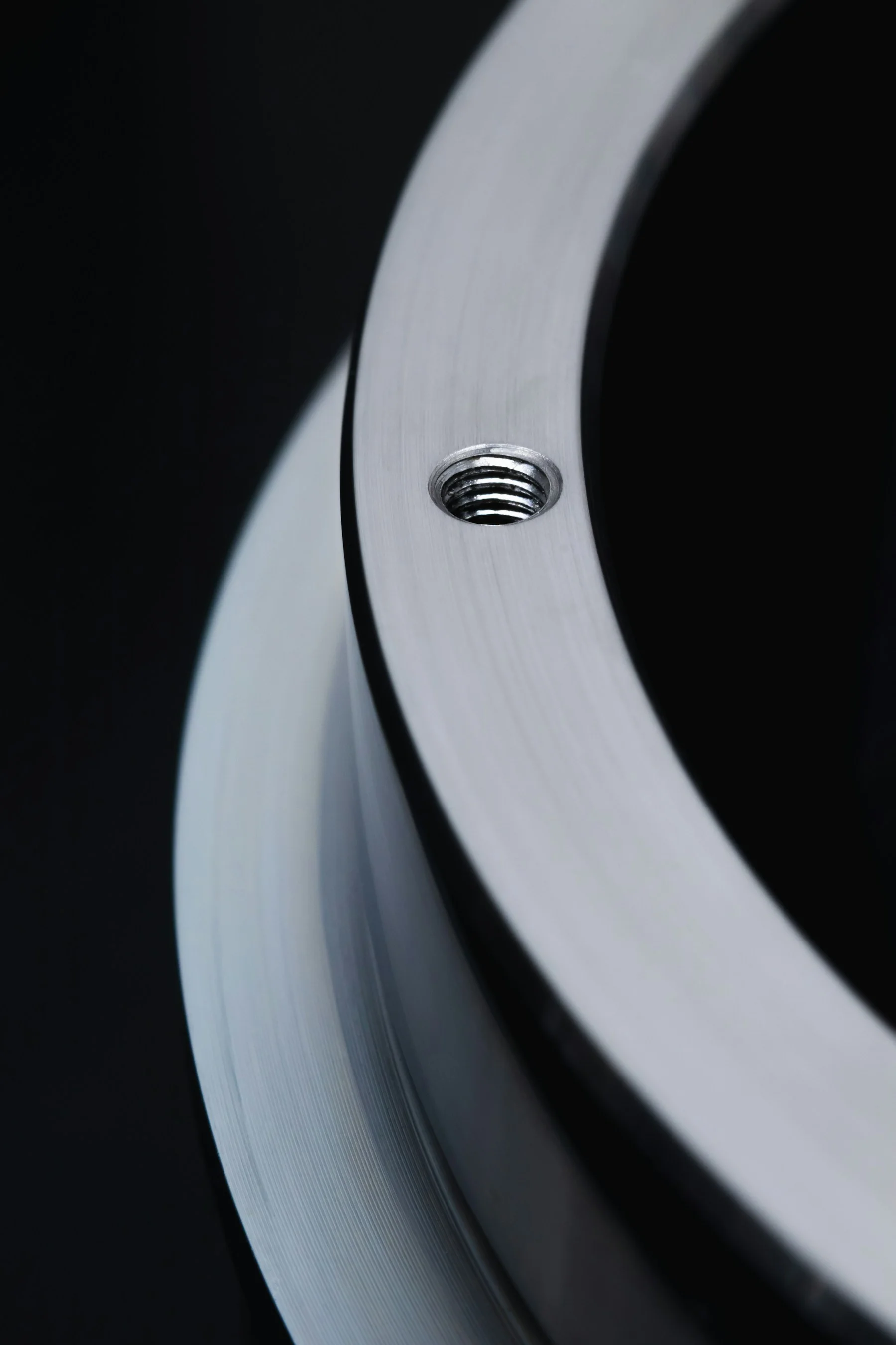 A machined metal interface with a precision threaded hole.