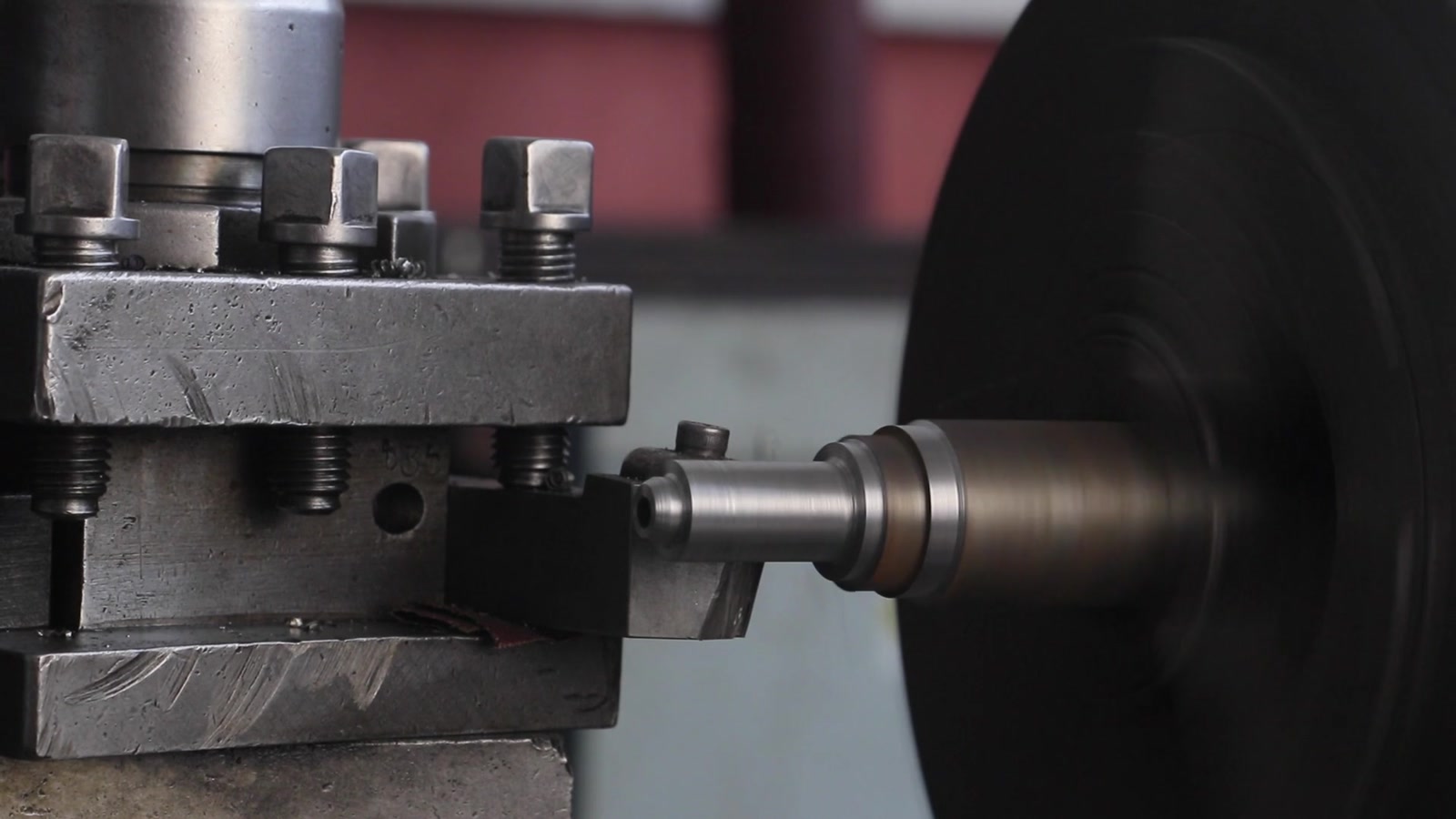 A metal component being machined on a lathe.