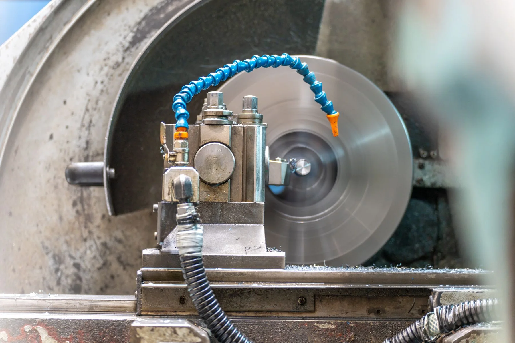 A rotating metal workpiece and cutting tool inside a lathe.